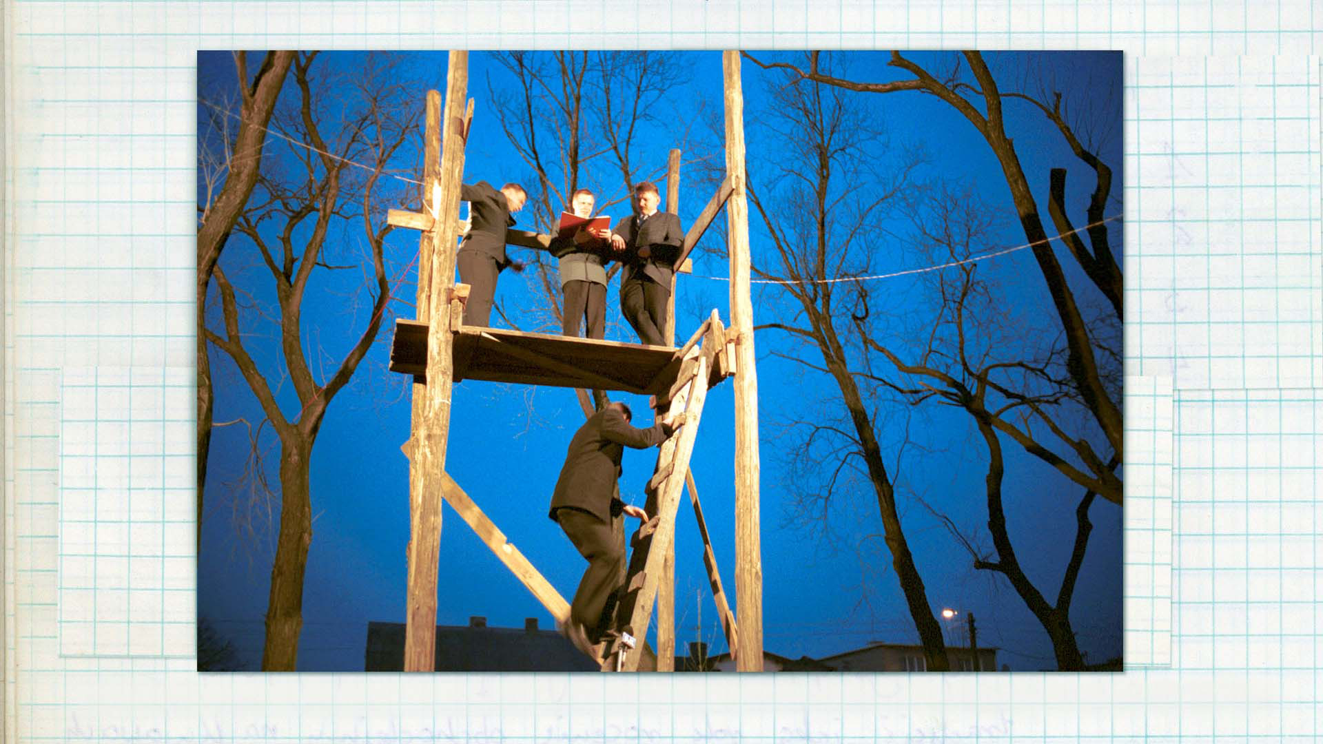 Wygłaszanie przywołówek, Niedziela Wielkanocna, 2004, fot. Damian Kramski Zdjęcie w kolorze. Po drewnianej drabinie wchodzi na trybunę wchodzi odświętnie ubrany mężczyzna. Na górze stoi trzech mężczyzn, także odzianych odświętnie. Jeden z nich w dłoniach trzyma czerwoną księgę.