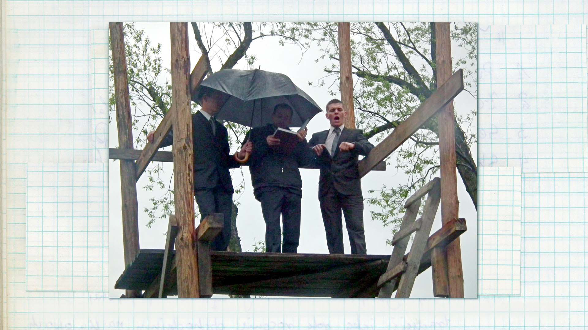 Wygłaszanie przywołówek, Niedziela Wielkanocna, 2014, Paula Kopeć Zdjęcie kolorowe. Trzech młodych mężczyzn, w eleganckich ubraniach stoi na górze trybuny. Jeden z nich najprawdopodobniej krzyczy, drugi trzyma w swoich dłoniach czerwoną książkę, trzeci trzyma rozłożony parasol.