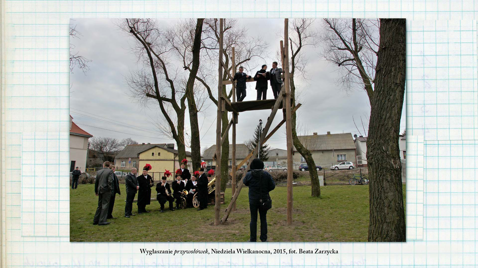 Wygłaszanie przywołówek, Niedziela Wielkanocna, 2004, fot. Damian Kramski Zdjęcie kolorowe. Trzech mężczyzn stojąc na drewnianej konstrukcji odczytuje notatki z czerwonej księgi.