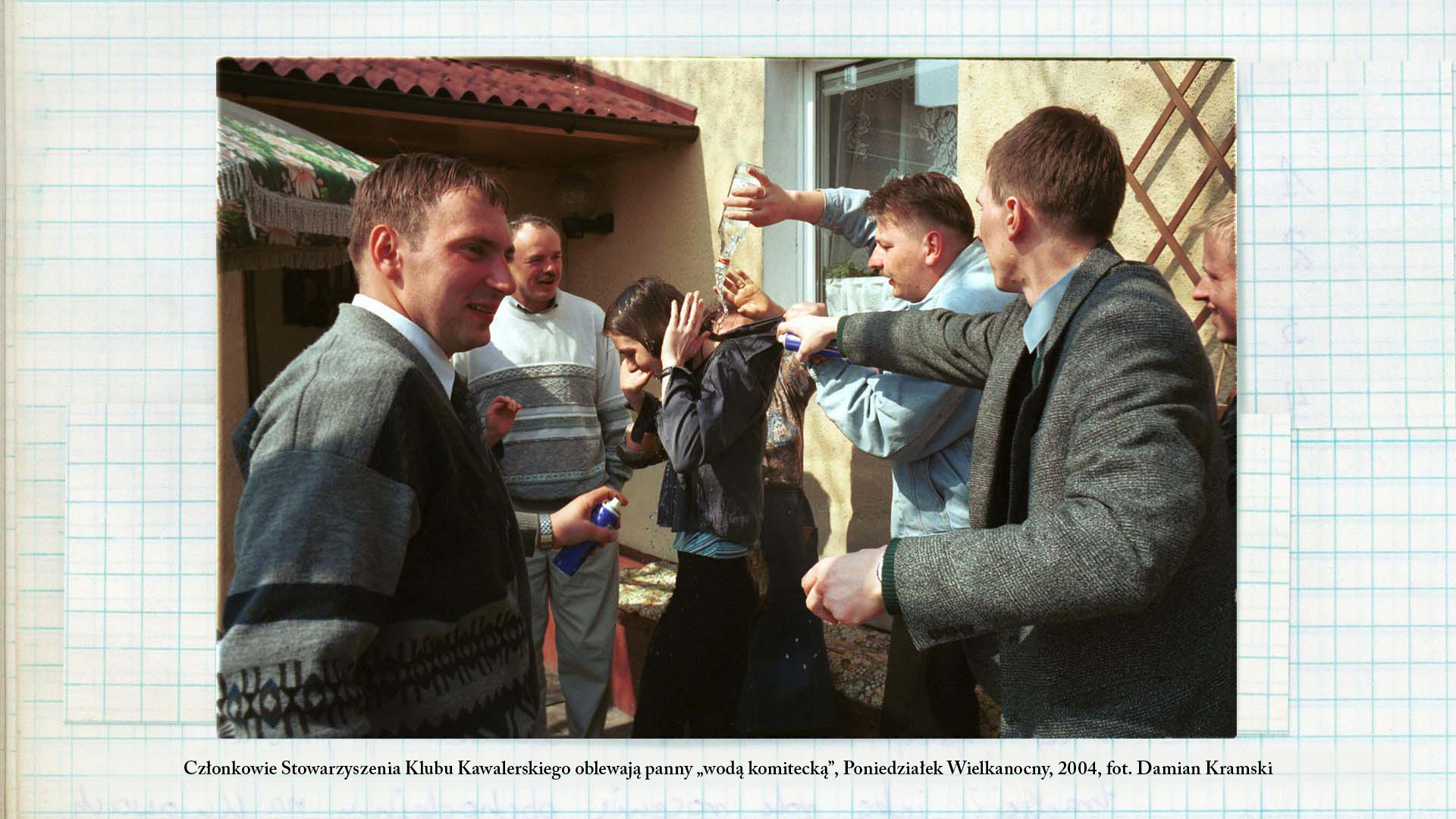Członkowie Klubu Kawalerskiego oblewają panny „wodą komitecką”, Poniedziałek Wielkanocny, 2004, fot. Damian Kramski Fotografia w kolorze. Grupa mężczyzn wylewa wodę z butelki na młodą dziewczynę.
